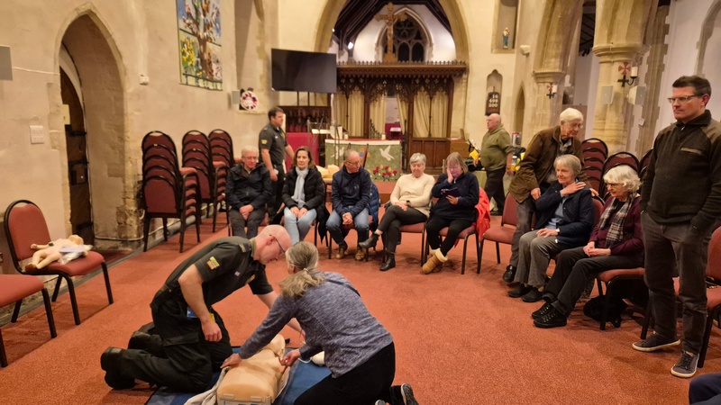 Attendees watching a CPR demonstration.
